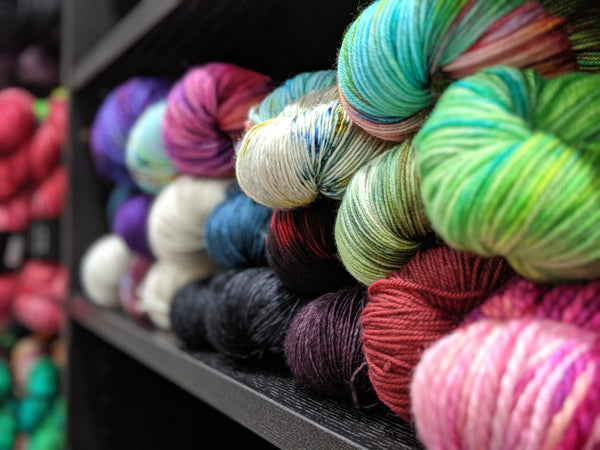 A neatly organized shelf filled with a vibrant assortment of multicolored yarn